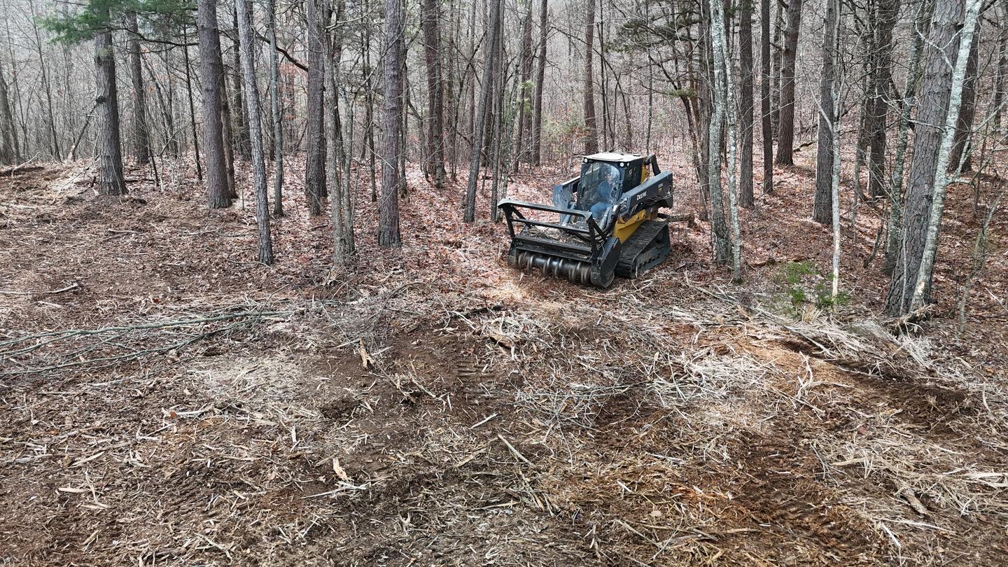 Forestry mulching equipment clearing brush on sloped Arkansas terrain